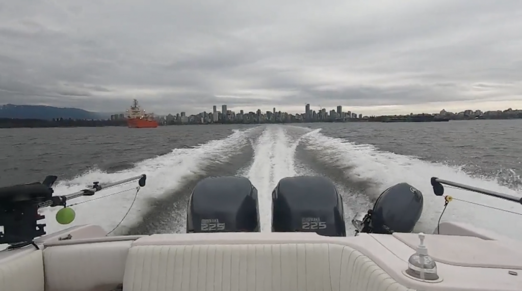 Travelling full speed in a boat away from downtown Vancouver