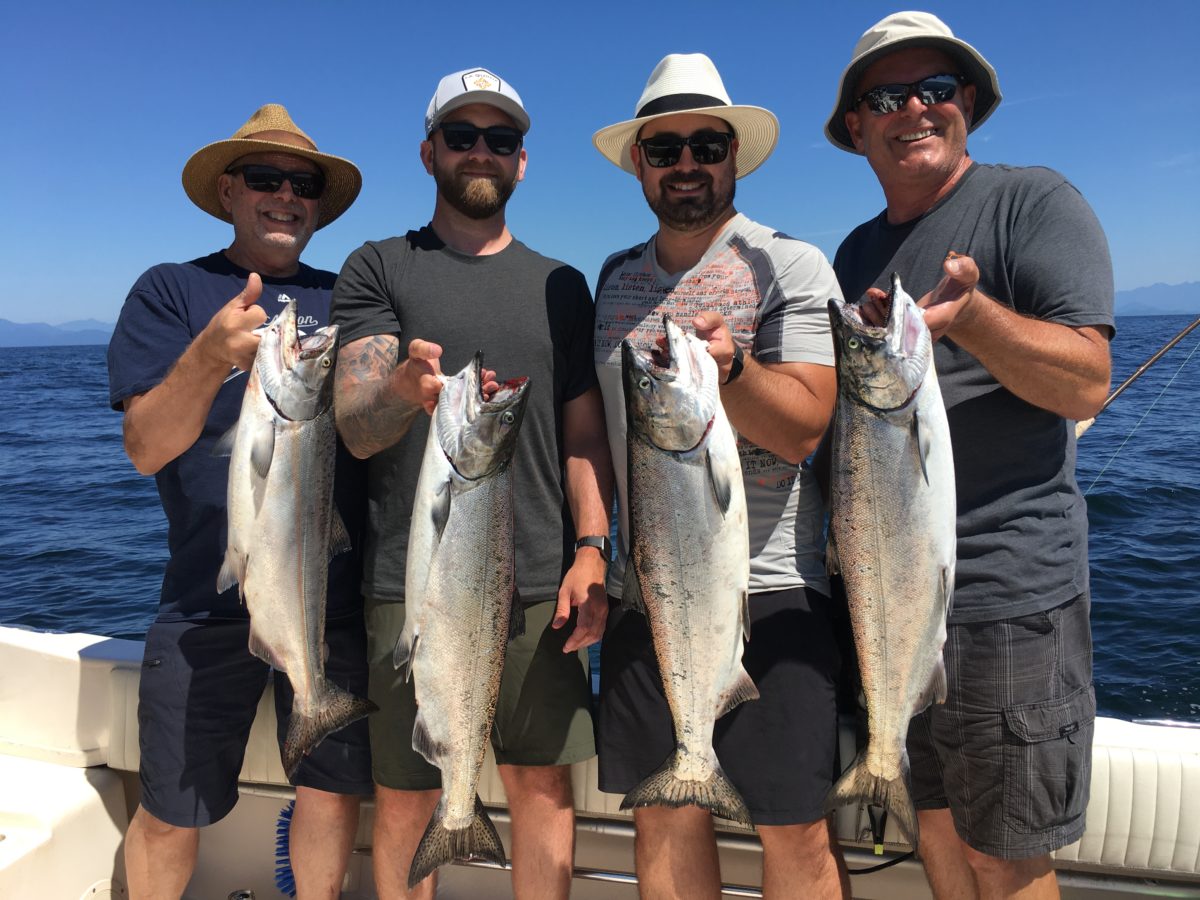 A group of guys holding up their salmon by the gills